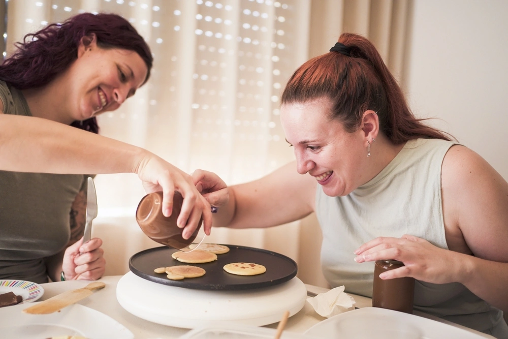 disabled women making pancakes with her carer