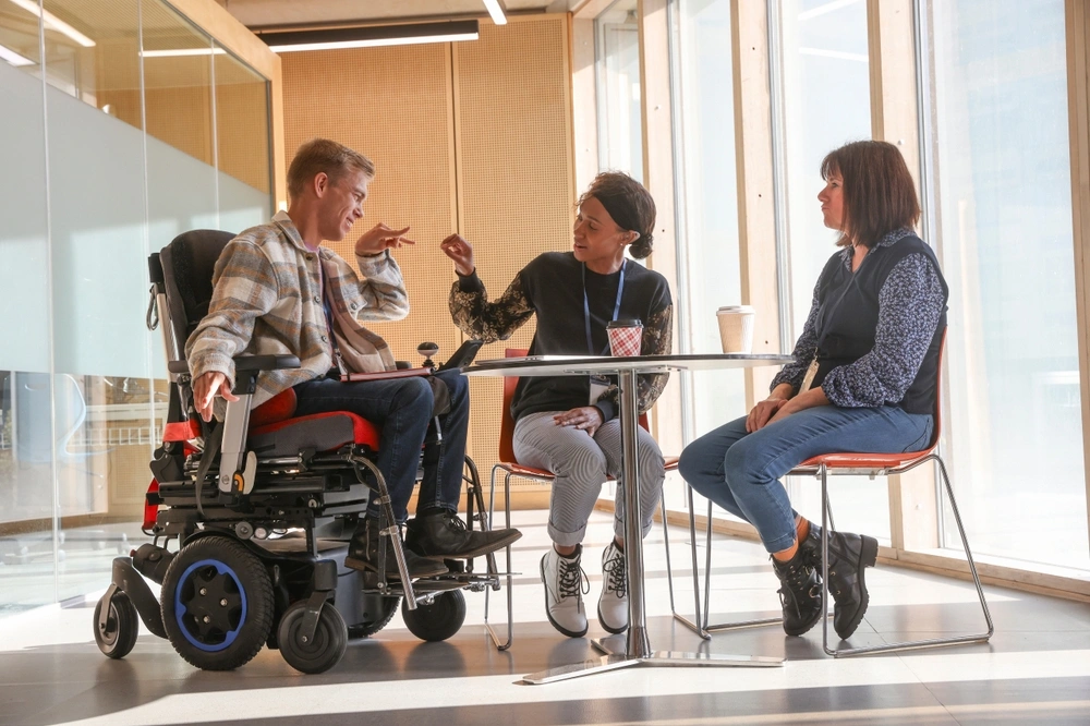 disabled person having conversation with his support providers